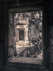 A view from the window of the brightly lit ruins of an ancient stone temple with elaborate stone carvings