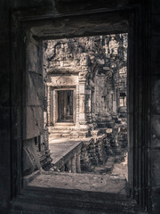 A view from the window of the brightly lit ruins of an ancient stone temple with elaborate stone...