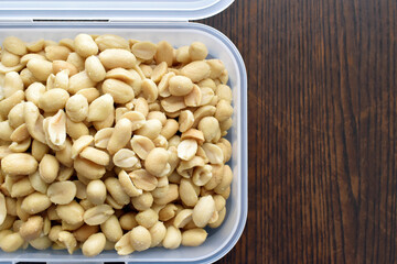 Salted peanuts in a plastic box.