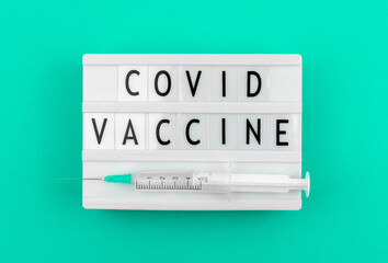 Covid vaccine vaccination agitational banner concept with syringe, top view photo