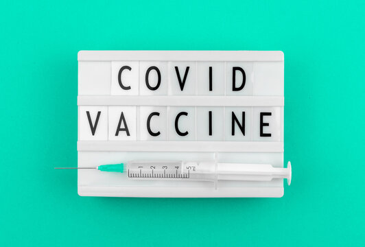 Covid vaccine vaccination agitational banner concept with syringe, top view photo