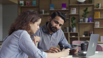 Professional indian teacher, manager or mentor helping latin student, new employee, teaching intern, explaining online job using laptop computer, talking, having teamwork discussion in office. - Powered by Adobe