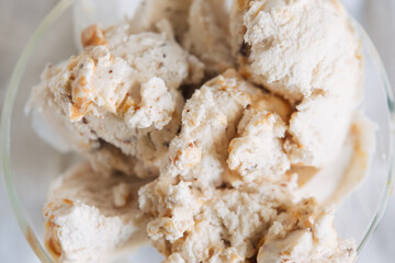 Top view of vanilla ice cream with chocolate chip cookies, chocolate chips and caramel sauce.
