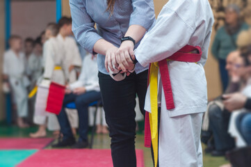 A young man in a white uniform with a red belt and gloves prepares for battle. karate-do training and a healthy lifestyle.