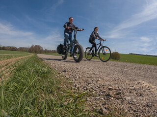 Young couple making bike trip with modern electric fat bike and trekking bike - 430025434