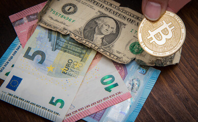 Euro banknotes ,american dollar and bitcoin coins, financial concept of global economic crisis.