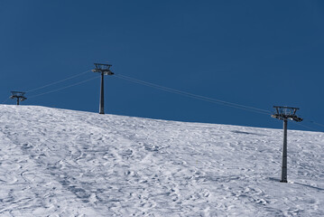 Fototapeta na wymiar Skipiste mit Skilift vor blauem Himmel