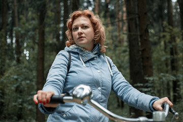 Fototapeta na wymiar Blond woman with bike in the woods.
