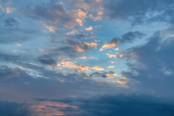 Fototapeta premium The sky at sunset. Cumulus clouds lit by the rays of the setting sun.