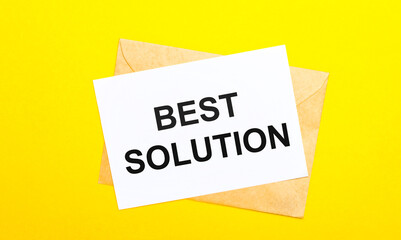 On a yellow background, an envelope and a card with the text BEST SOLUTION. View from above