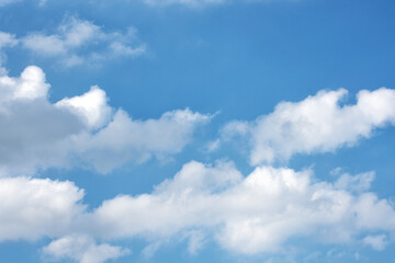 Naklejka na ściany i meble Fluffy white clouds on background of blue sky.