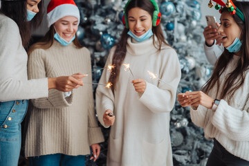 Multi-ethnic young people celebrating New year eve holding sparklers