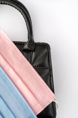  pink and blue protective masks in a black elegant handbag