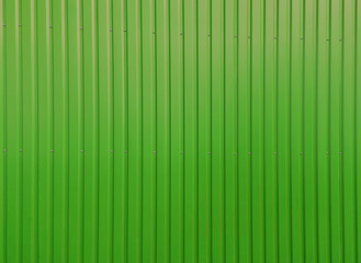 Building wall clad in green plastic siding