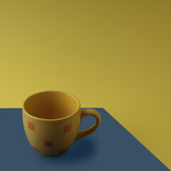 Yellow cup on a blue and yellow background

