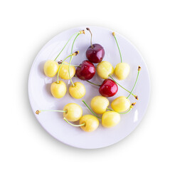 A group of yellow and red cherries on a plate. Isolated over white background. Sweet cherry