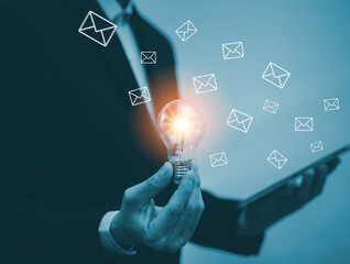 Business holding light bulb, innovative idea of ​​inspiration from online technology, email with the laptop, Businessman hand pressing the keyboard for sending the e-mail from the laptop computer