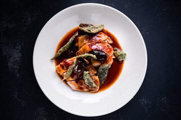 Tasty chicken steaks with sage and garlic sauce closeup on a plate top view, flat lay