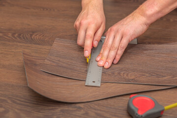 DIY vinyl flooring. Easy installation and cutting with a knife, Master cuts vinyl plank before...