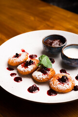 Vertical photo of some cheese pancakes on a wooden table.