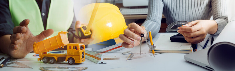 Engineers or architects is watching on model building and blueprint in working site.Construction...