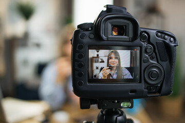 Charming young woman recording video tutorial about using professional cosmetics at home. Beauty...