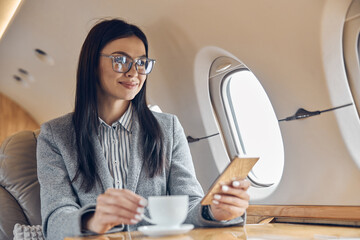 Happy smiling beautiful business woman in private jet