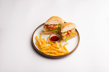 Top view of a plate with two delicious chicken sandwiches and some french fries .