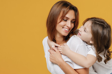Happy woman in basic white t-shirt have fun with cute child baby girl 5-6 years old hugs. Mommy...
