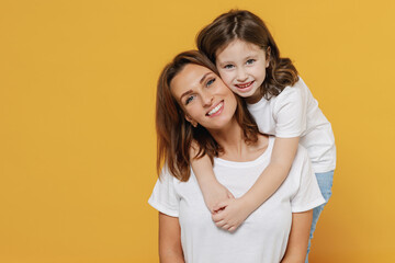 Happy woman in basic white t-shirt have fun with cute child baby girl 5-6 years old hugging. Mom...
