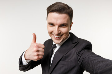 Close up young employee business corporate lawyer man in classic formal black grey suit shirt tie work in office do selfie shot mobile phone show thumb up gesture isolated on white background studio.
