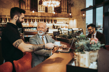  Waiter serving coffeeto the business people in restaurant.