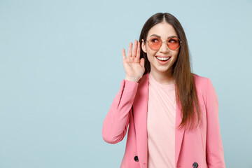 Young curious nosy smiling fun caucasian woman 20s in pastel pink clothes glasses try to hear you...