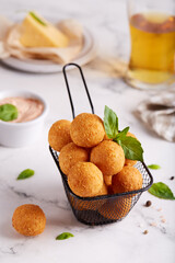 Deep fried Cheese balls. Delicious homemade appetizer. Freshly baked croquettes, served with basil leafs and sauce.