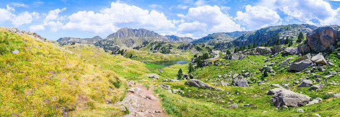 Panoramic view of mountainous landscape with beautiful green mountains and a lake on a sunny day. Concept of mountain trip and summer vacations. Circo Saboredo, Aran Valley-Pyrenees, Catalonia, Spain.