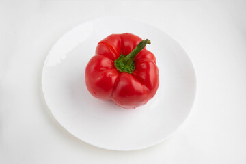 Red pepper on a white plate, isolated on a white background