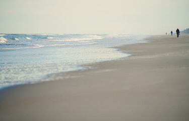 Incidental people walking along the beach of Atlantic Ocean. USA