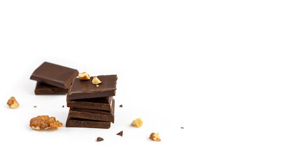 Slices of dark chocolate sprinkled with walnuts isolated on white background