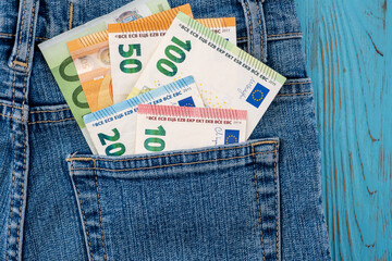Euro banknotes peeking out of the back pocket of jeans