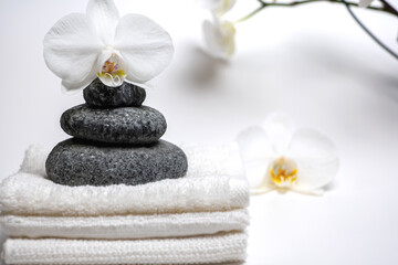 Obraz na płótnie Canvas spa style, white towels, honey cup, Zen stones, orchid: everything for a relaxing massage