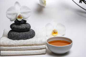 Obraz na płótnie Canvas spa style, white towels, honey cup, Zen stones, orchid: everything for a relaxing massage