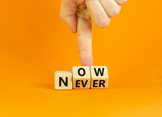 Now or never symbol. Businessman turns wooden cubes and changes the word 'never' to 'now' or vice versa. Beautiful orange background, copy space. Business and now or never concept.