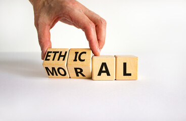 Ethical or moral symbol. Businessman turns wooden cubes and changes the word 'moral' to 'ethical'...