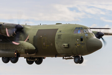 PEMBREY, WALES - APRIL 13 2021: A Royal Air Force Lockheed C-130J 'Super Hercules' performing tactical landings and takeoffs from the public beach at Cefn Sidan Sands in West Wales. - obrazy, fototapety, plakaty