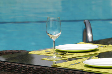 An Empty Wine Glass on the Table Beside the Swimming Pool