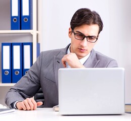Young handsome businessman employee working in office at desk
