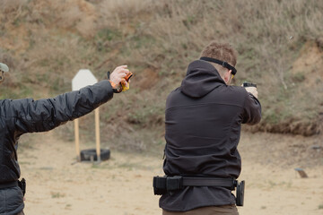 Man fires automatic handgun pistol during training in practical shooting. Man with gun, gangster....
