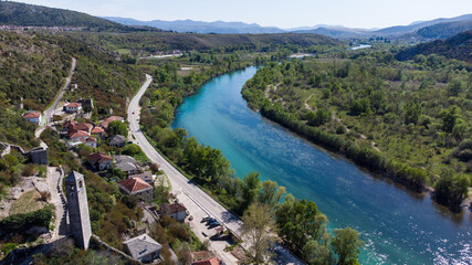 Aerial drone view of river Neretva and Pocitelj. Old town Počitelj in Bosnia and Herzegovina, view from above. Old fortress on the hill. Neretva valley.