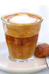 decorated glass of Coffee Piccolo Latte on a white table in a Sydney Cafe NSW Australia
