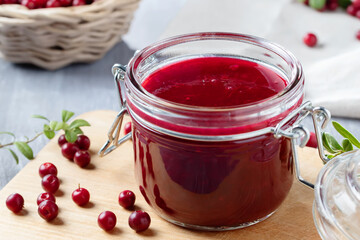 Glass jar with homemade lingonberry sauce. Canning lingonberry sauce